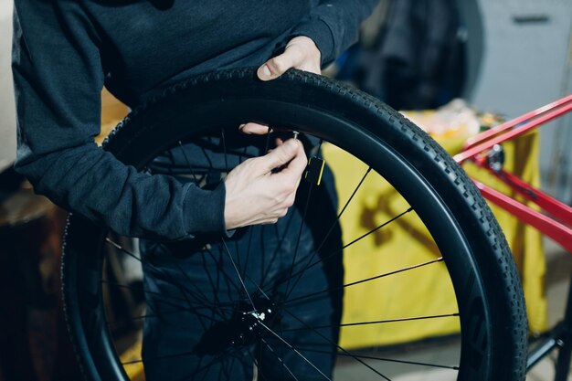 ワーク ショップでホイール ニップル リム カスタム自転車を組み立てるメカニック修理工