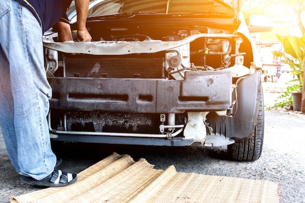 Foto il meccanico ripara l'auto e mantiene il veicolo in garage. concetto di guida e trasporto.