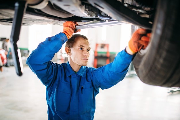 Mechanic repairs the suspension, car on the lift