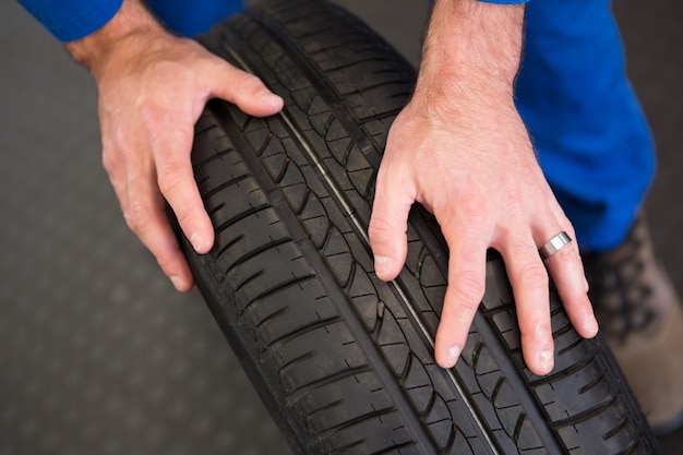 Mechanic rolling a tire wheel