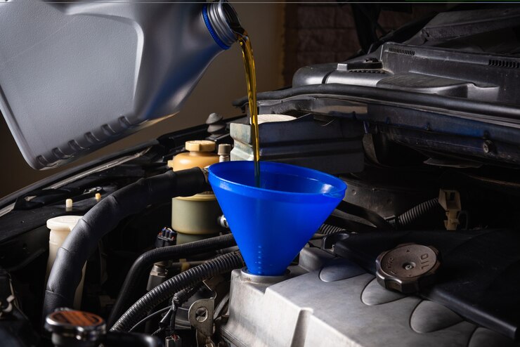 Photo mechanic in service to repair the car refueling and pouring from bottle to change lubricant oil