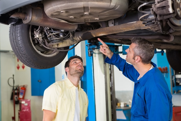 Mechanic showing customer the problem with car