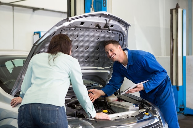 Mechanic showing customer the problem with car