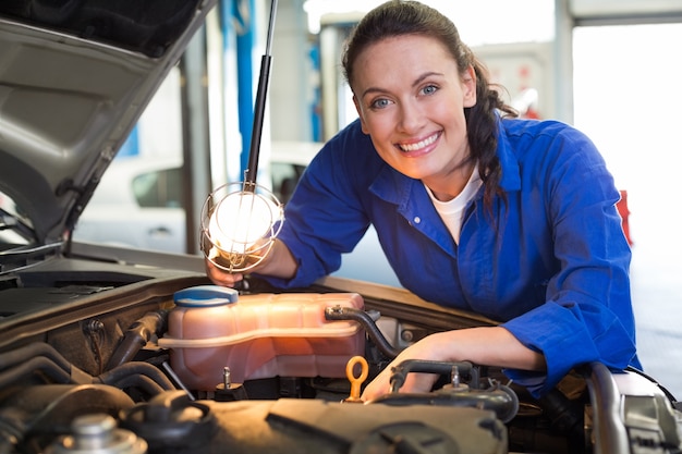 Mechanic smiling at the camera with torch