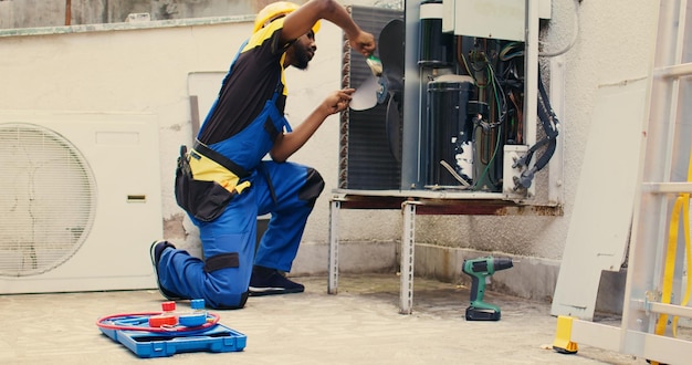 mechanic sweeps debris in condenser