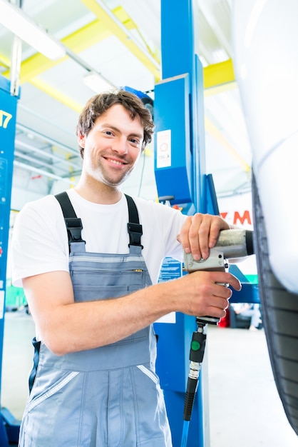 Mechanic tire change in car workshop