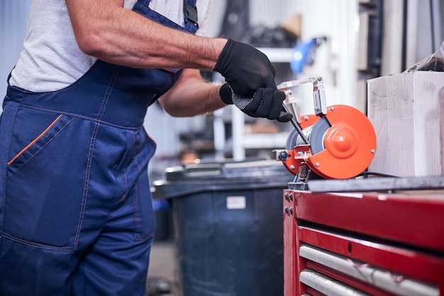 Mechanic using grinding machine at auto repair shop