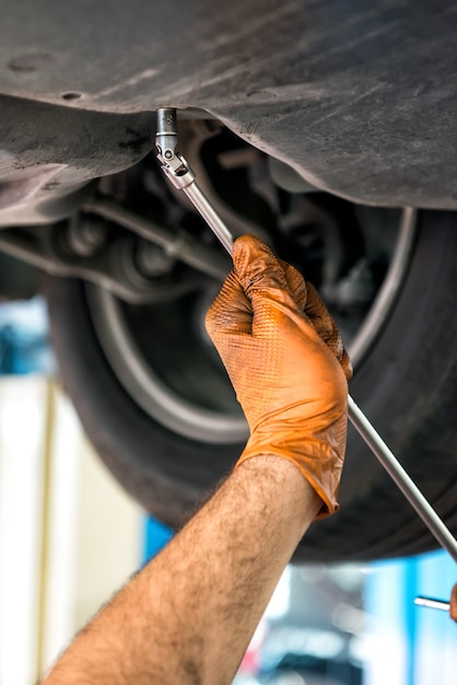 Mechanic using a wrench on a car