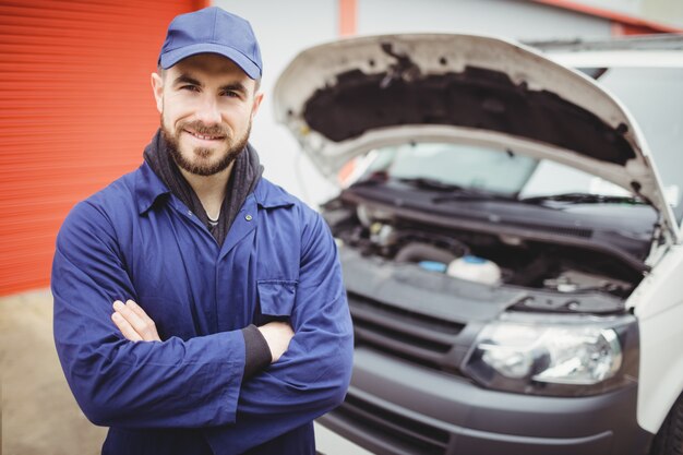 Mechanic with arms crossed standing in front of a van