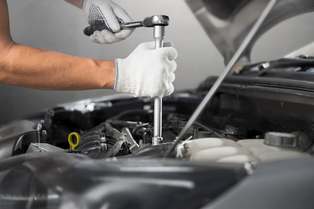 Mechanic working in auto repair garage. Car maintenance.