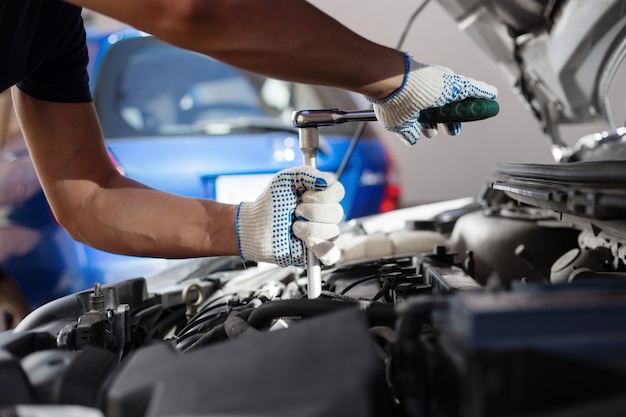 Mechanic working in auto repair garage. Car maintenance.