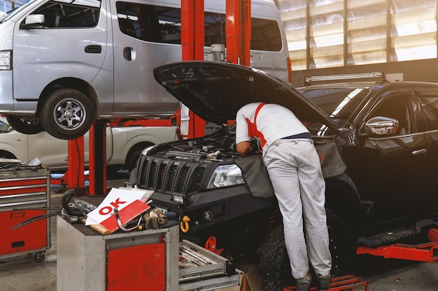 Mechanic working car maintenance with soft-focus and over light in the