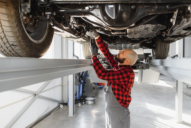 Mechanic working under car at the repair garage