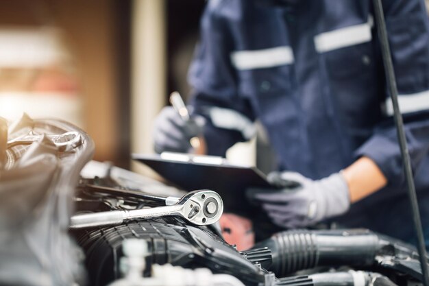 照片机械汽车的发动机工作在车库里。维修服务。汽车检测服务和汽车维修服务的概念。