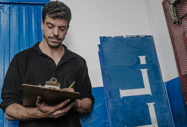 Mechanic writing on clipboard in garage