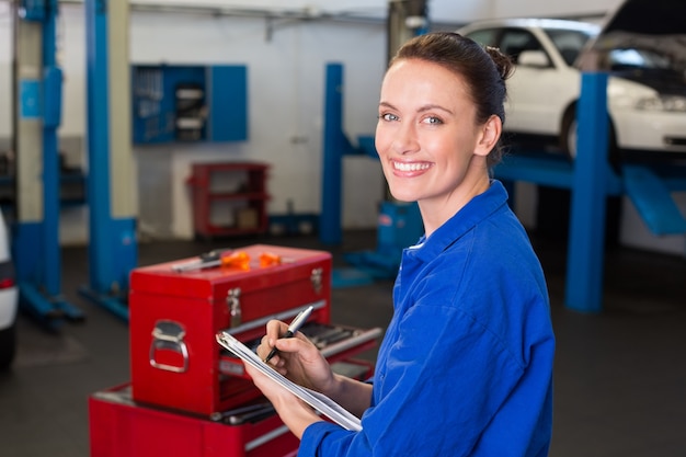 Mechanic writing on a clipboard