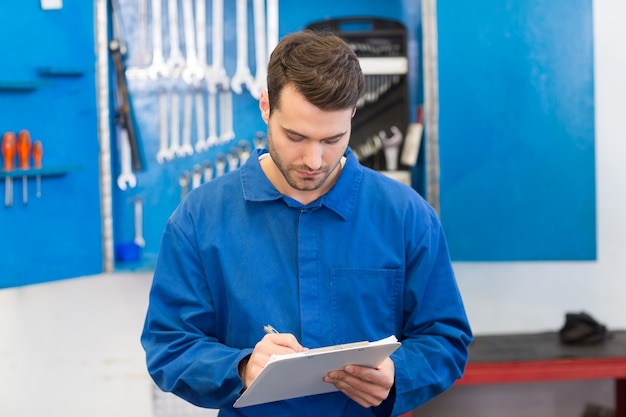 Mechanic writing on a clipboard