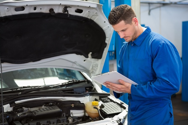 mechanic writing on a clipboard