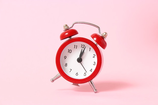 Mechanical alarm clock on a colored background