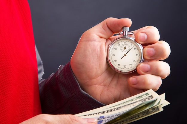 Механический аналоговый секундомер и доллары в руке бизнесмена Неполная точность для делового бизнеса и финансового времени