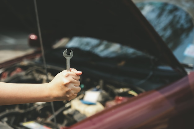 Mechanical engineer hands open the car skirt to check the oil level of the car. 