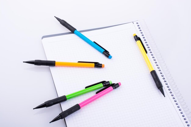 Mechanical pencils of various color on a notebook