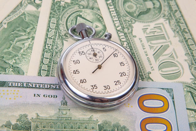 Mechanical stopwatch on the background of dollars Part time accuracy for business business and finance time