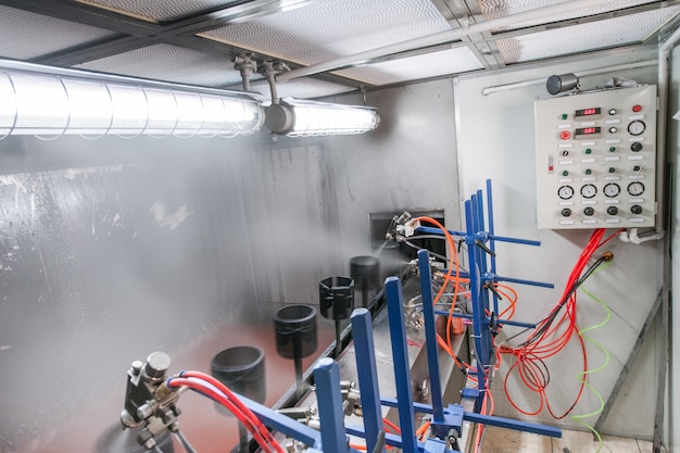 Mechanical workshop of painting details on a conveyor belt through a spray bottle