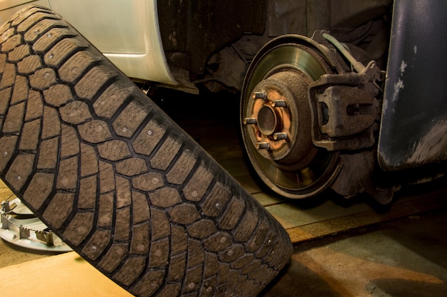 Meccanico che cambia la ruota dell'auto in garage. l'uomo lo scambio di pneumatici. servizio pneumatici. montaggio pneumatici.