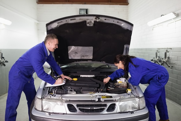 Mechanics examining a car engine