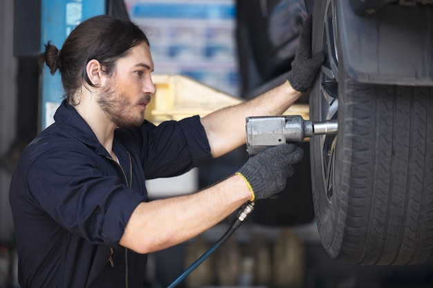 Meccanica che fissa pneumatici auto in garage