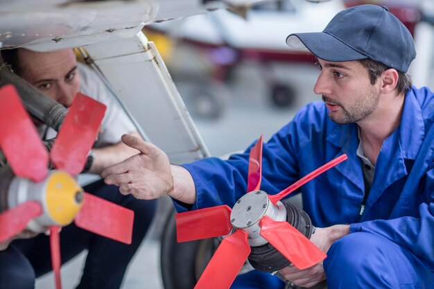 Mechanics in hangar repairing light aircraft