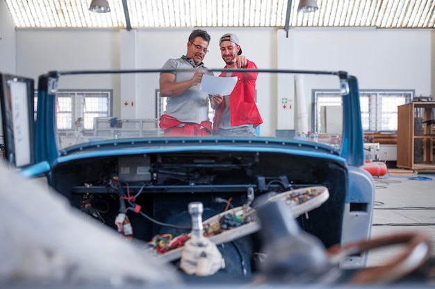 Photo mechanics restoring vintage cars in workshop