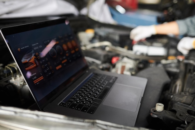 Mechanics using program on laptop when analyzing car computer systems and components