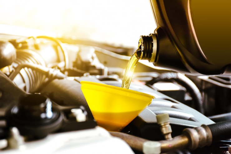Mechanicus die motorolie naar de motor giet in de reparatiewerkplaats