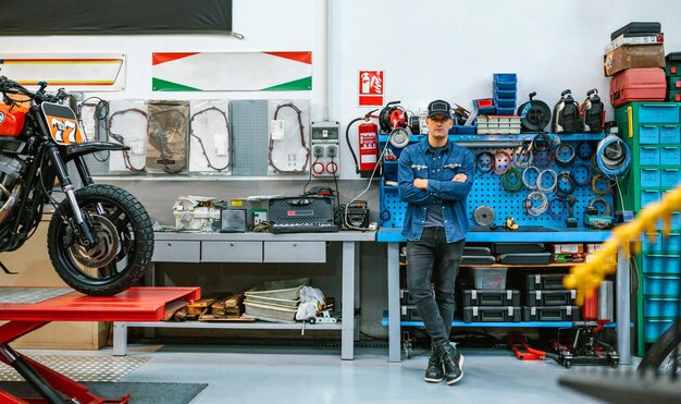 Foto mechanicus die voor de werkbank staat in een motorwerkplaats
