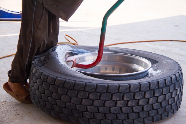 Mechanisch in zijn werkplaats die banden vervangt. Bandreparatie. De werknemer reparatie van band.