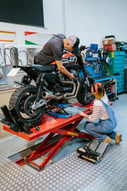 Mechanisch team dat de motor van de motorfiets in de fabriek beoordeelt