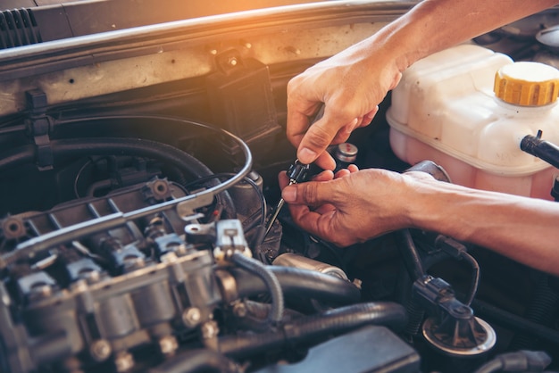 Mechanische mensenhanden die auto in automobiel mobiel autocentrum bevestigen.