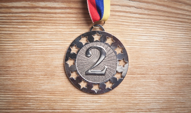 Medal awards for winner on wooden table.