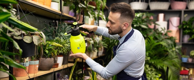 Medewerker bloemenwinkel zorgt voor potplanten