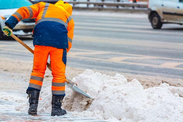 Medewerker gemeentelijke diensten verwijdert sneeuw van de weg in de winter Reiniging van stadsstraten en wegen tijdens sneeuwstorm Moskou Rusland