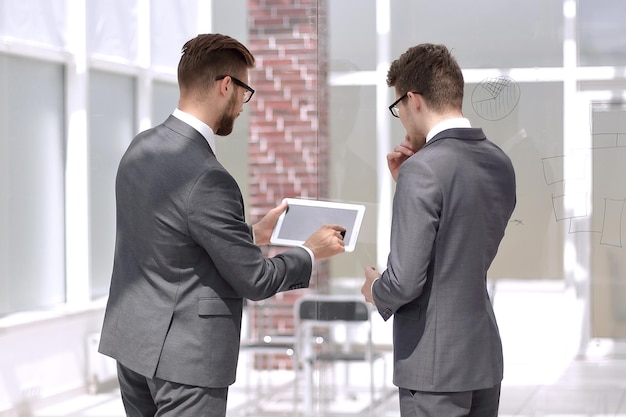 Medewerkers bespreken informatie met behulp van een digitale tabletfoto uit kopieën van de ruimte