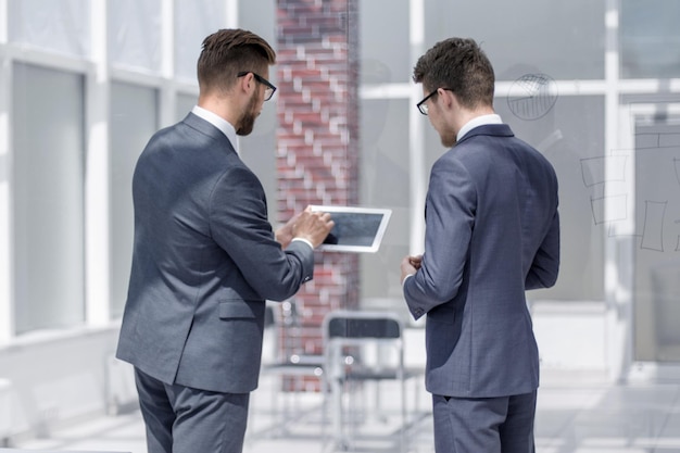 Medewerkers bespreken informatie met behulp van een digitale tabletfoto uit kopieën van de ruimte