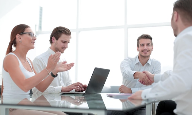 Medewerkers juichen de zakenpartners aan de onderhandelingstafel toehet concept van samenwerking