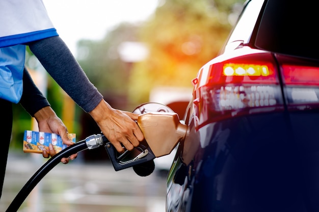 Medewerkers maken zich klaar om de auto te tanken. Transport en industriële concepten. Vul de auto. Plaats de tankklep in de tankhals.