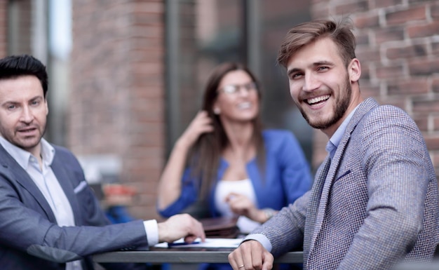 Medewerkers van het bedrijf zitten aan een tafel in een straatcafé