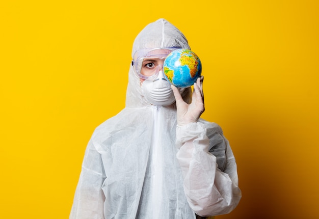 Medic in beschermingspak en masker houden Earth globe vast