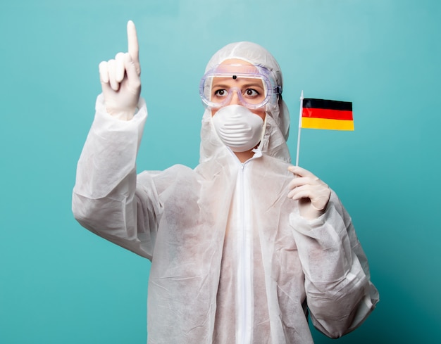 Medic woman wearing protective clothing against the virus holds Germany flag