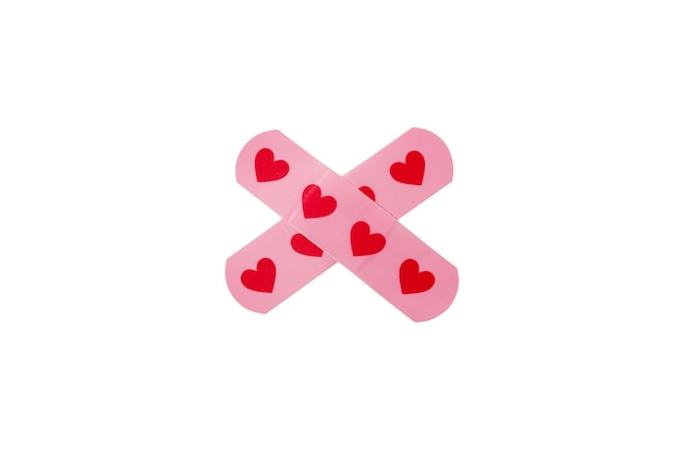 Пластырь медицинский скотч, розовый с сердечками, изолированный на белой предпосылке. Крестообразный. Защита и уход.